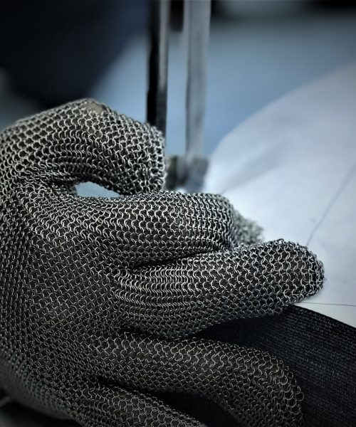 A close-up view of hands expertly working on a garment, illustrating direct engagement with a clothing factory renowned for its high-quality manufacturing and guidance