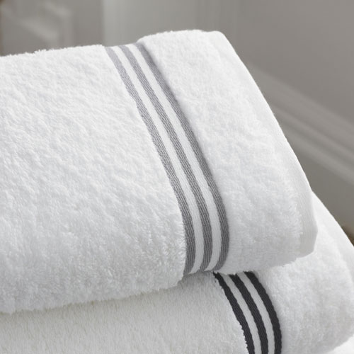 Close-up of fluffy hotel towels on a neatly made bed in a luxury hotel room