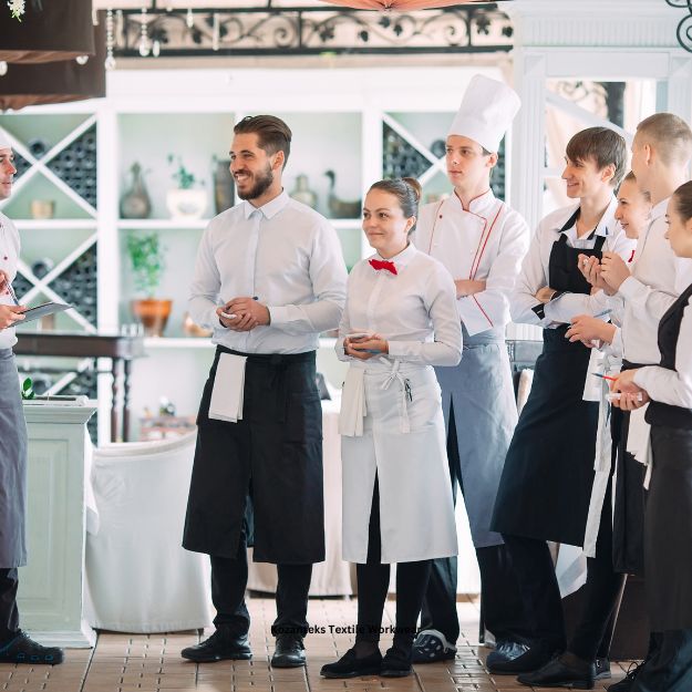 A chef wearing a professional, white chef's jacket with a custom embroidered logo.