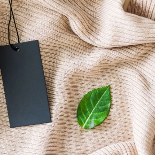 Eco-friendly knitwear with a tag and green leaf.