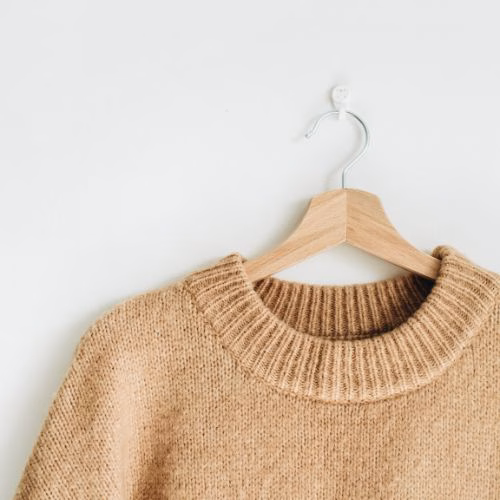 Sustainable knitwear displayed on a hanger.